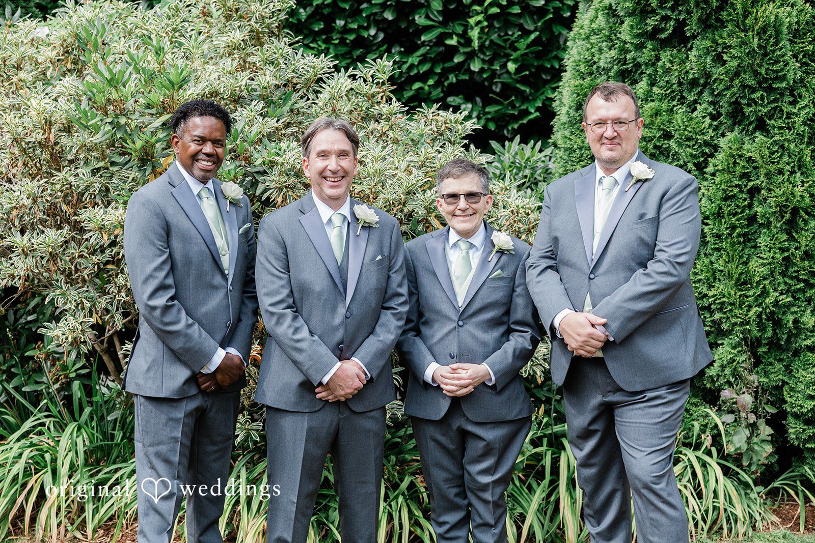 Kim + Keven A group of men in grey suits posing together.
