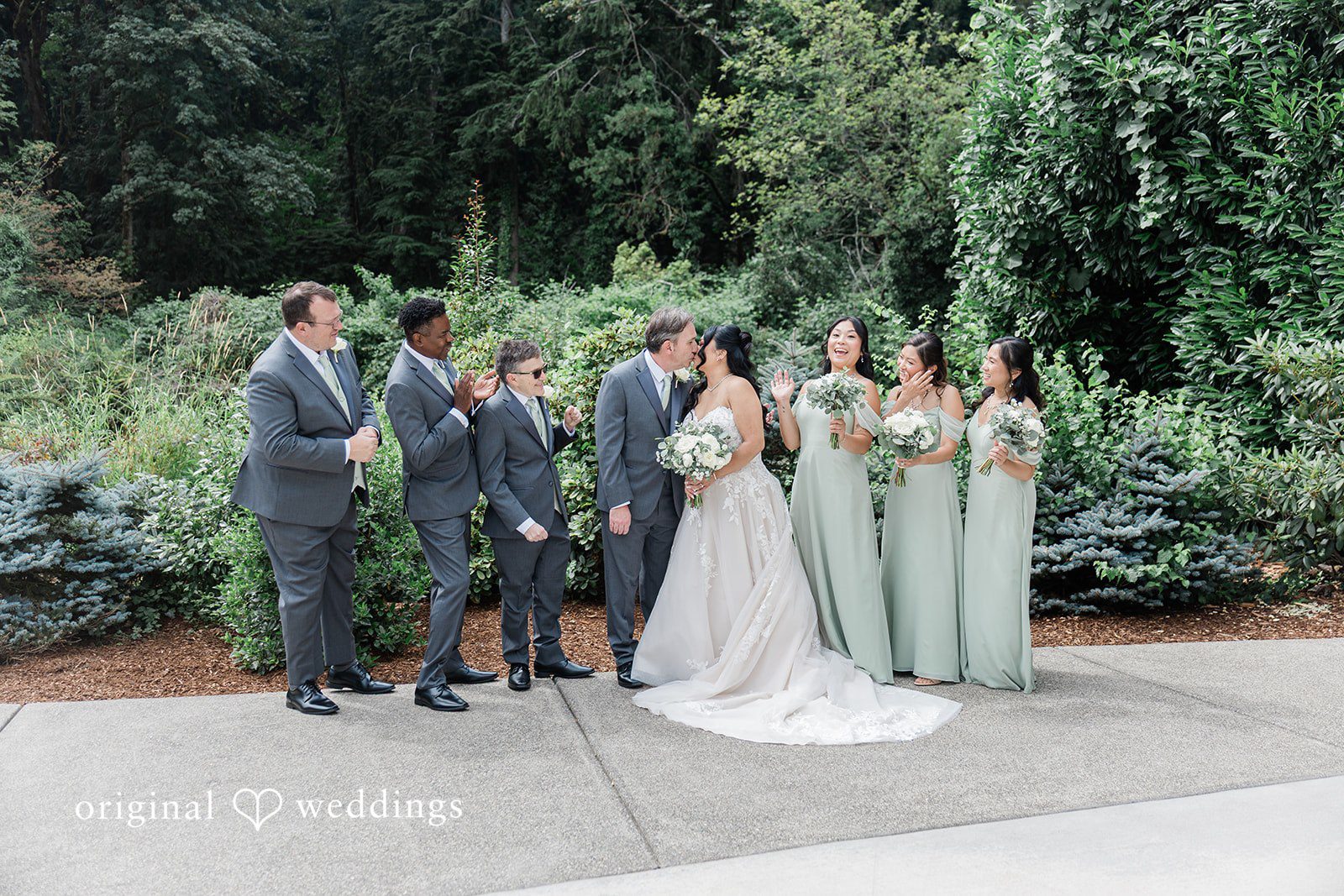 Kim + Keven A wedding party in suits and gowns posing together outside.