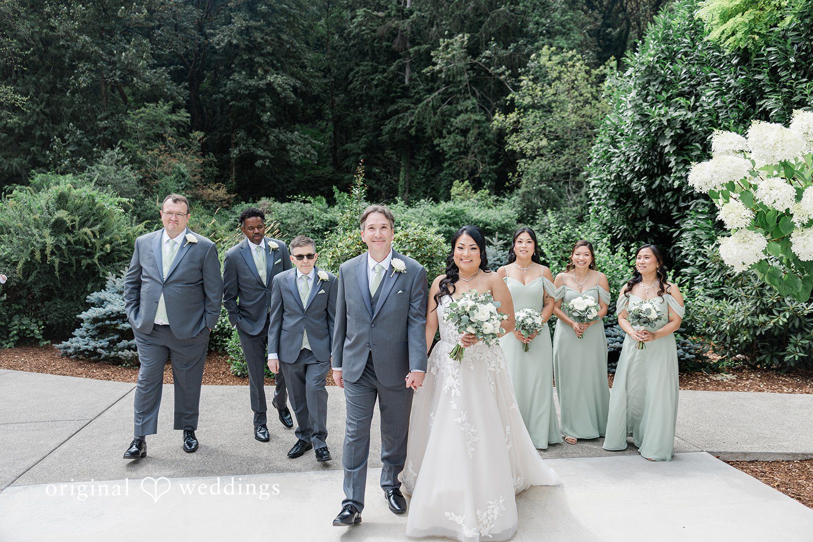 Kim + Keven A bridal party standing and posing together on a path.