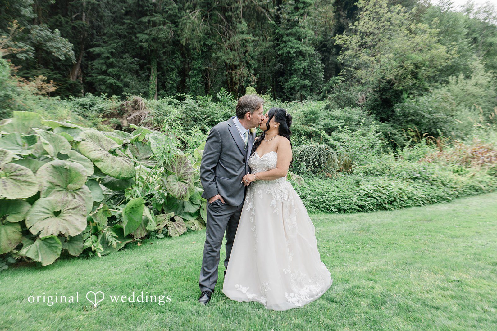 Kim + Keven A bride and groom posing together in front of trees.
