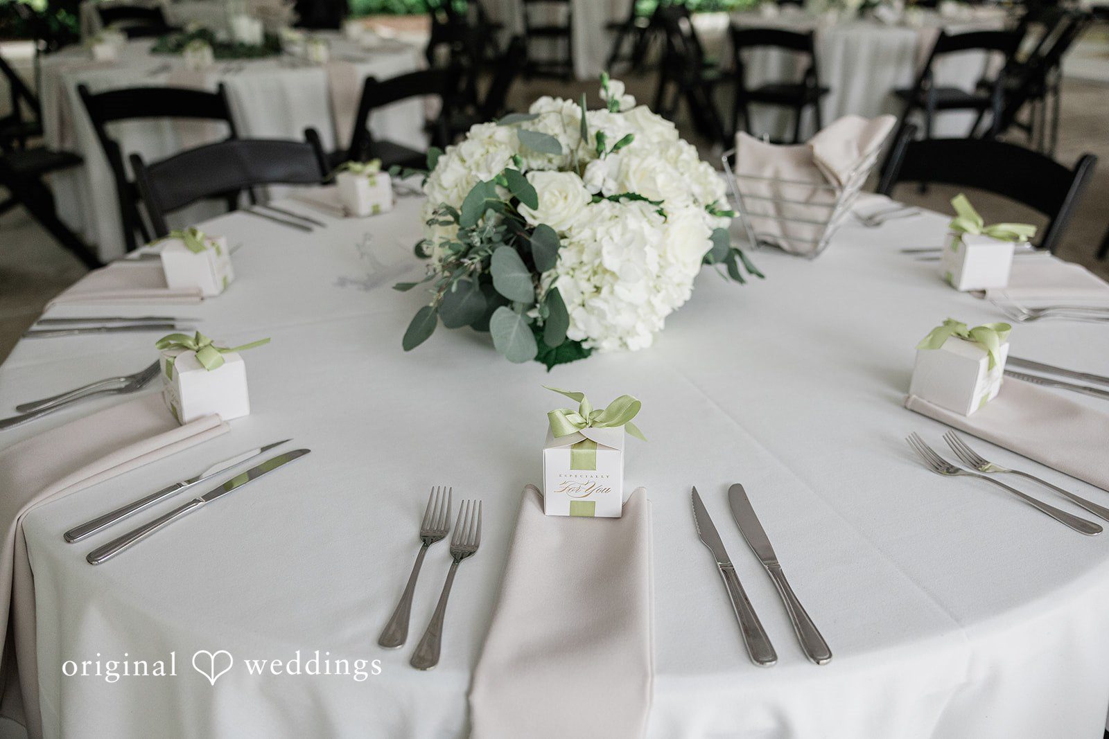 Kim + Keven A round dinner table set with white linen and tableware.