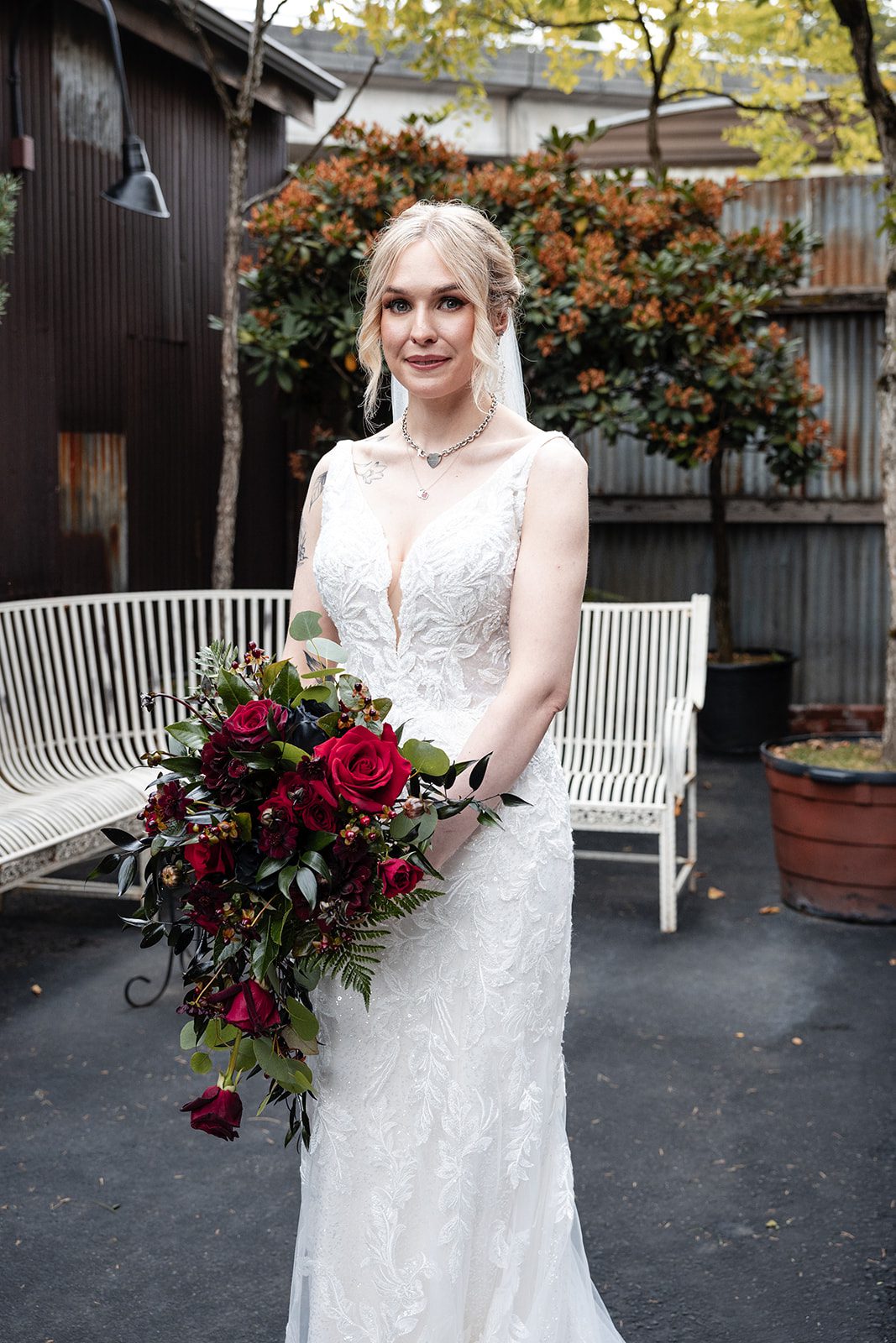 Bride holding her red bouquet in the courtyard Bride holding her red bouquet in the courtyard
