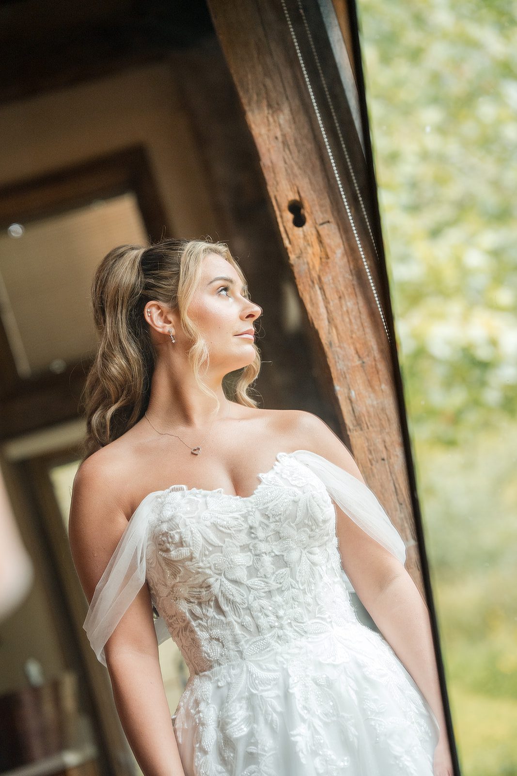 Bride looking out the window in her gown