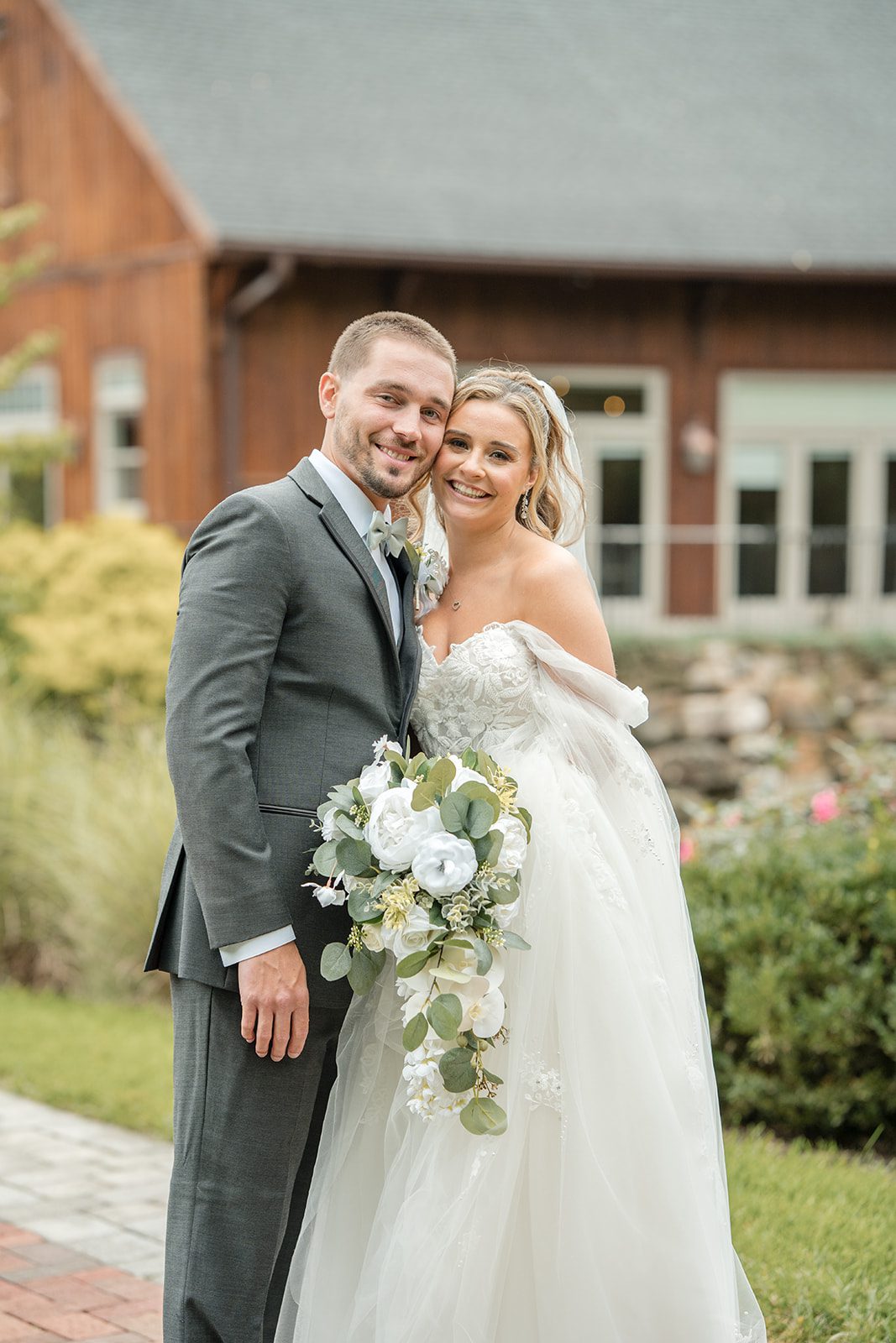 Bride and groom smiling in front of the barn