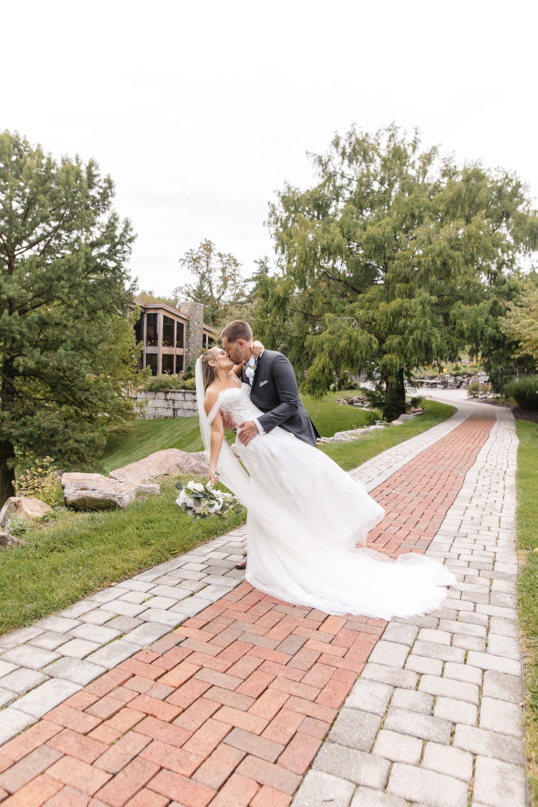 Groom dipping the bride on the brick path