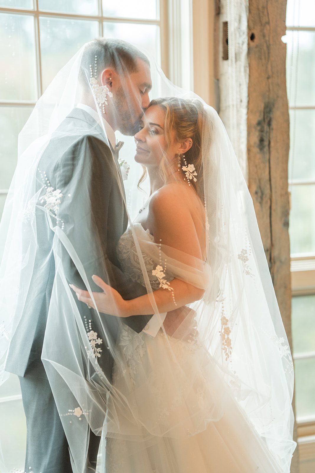 Romantic veil portrait by the window, captured by Philadelphia wedding photographers