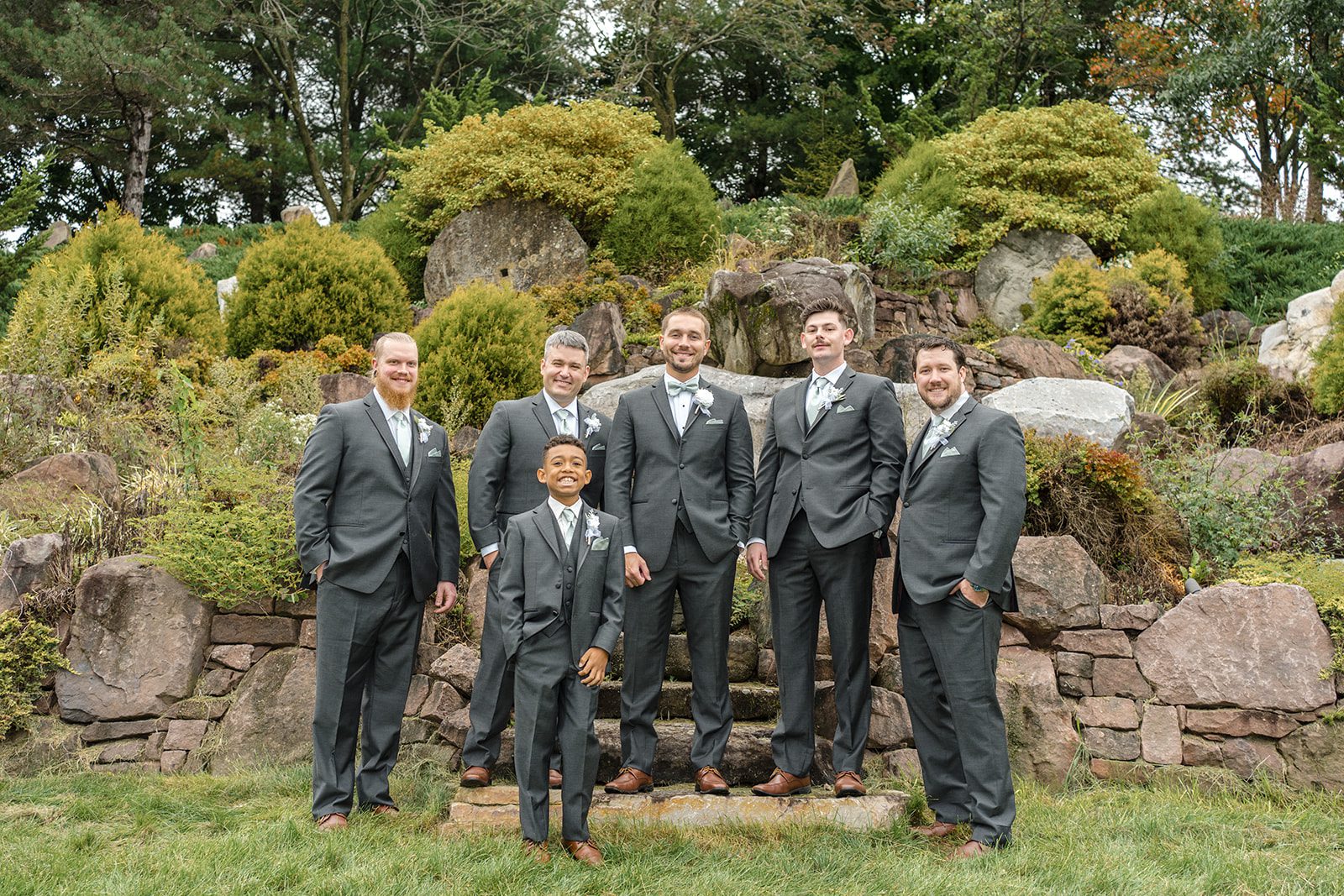 Groom with his groomsmen by the rock garden