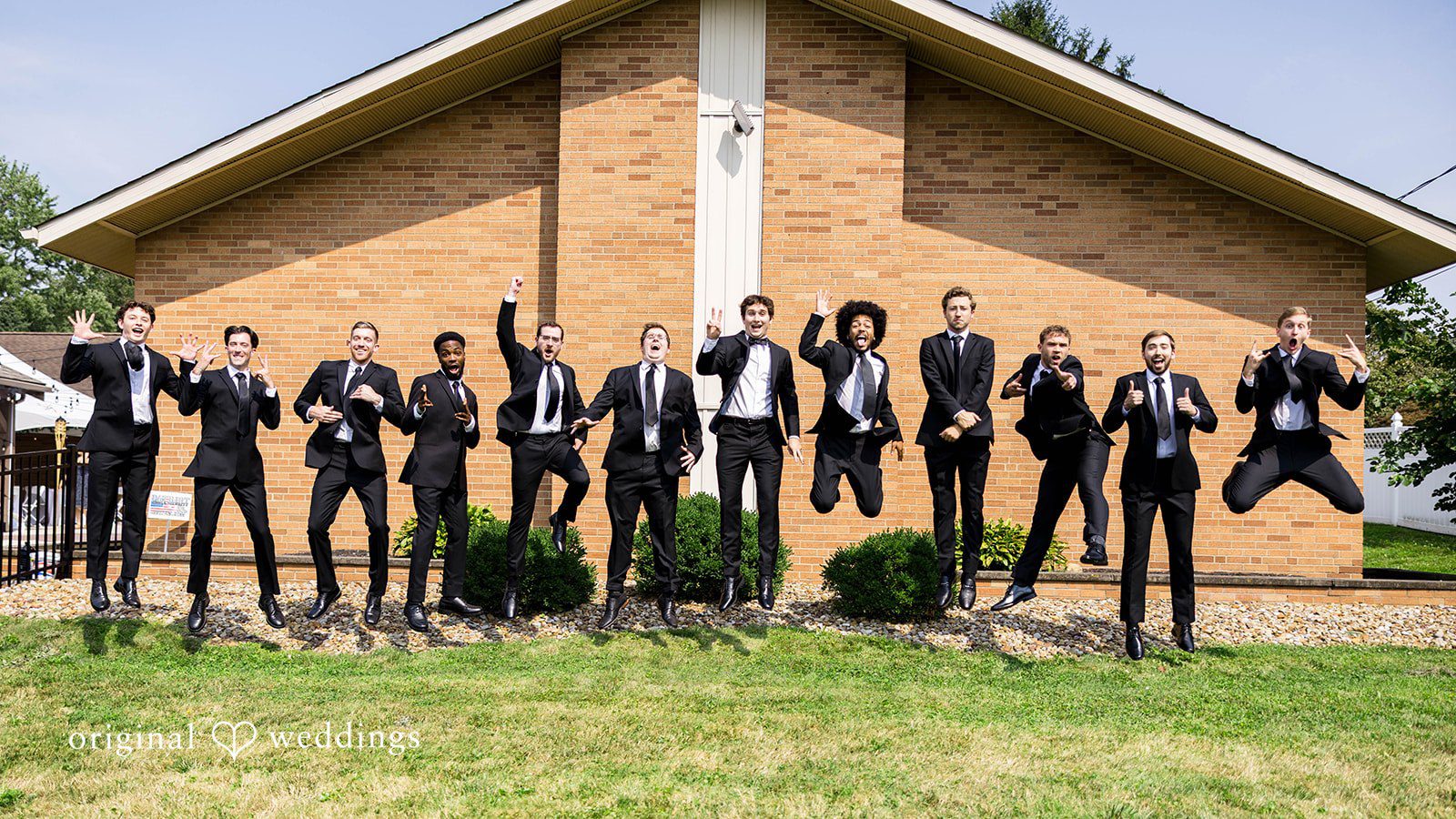 Ethan + Kelcy Groomsmen jumping in front of Grace Church Barberton