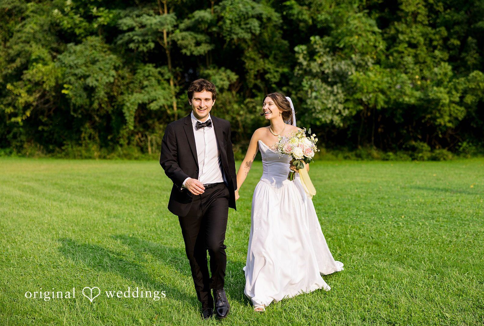 Couple walking hand in hand across the lawn, captured by Cleveland wedding photographers from Original Weddings at Grace Church Barberton