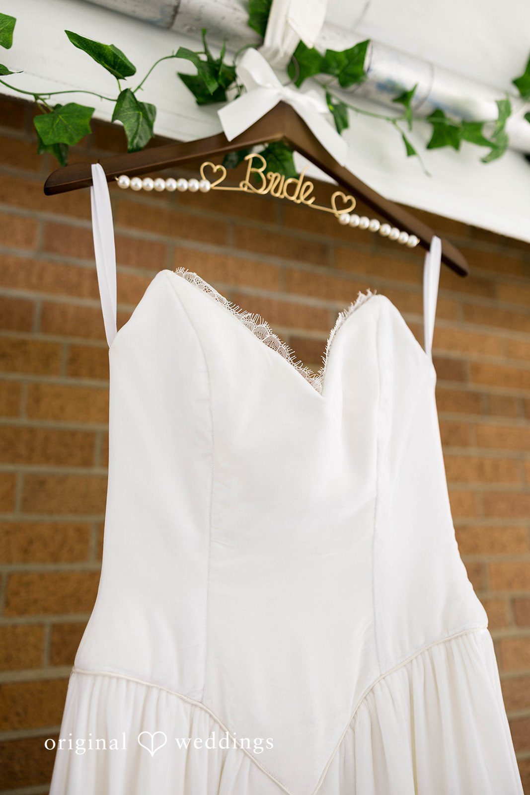 Ethan + Kelcy Wedding dress hanging on a hanger