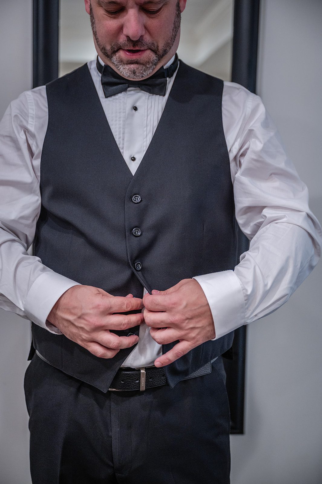 harbor-lights-timeless-providence-feng-donald-p012-43 Groom buttoning his vest while getting ready