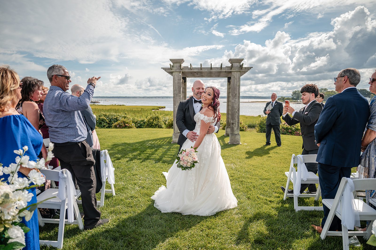 harbor-lights-timeless-providence-feng-donald-p030-38 Couple walking back up the aisle as newlyweds