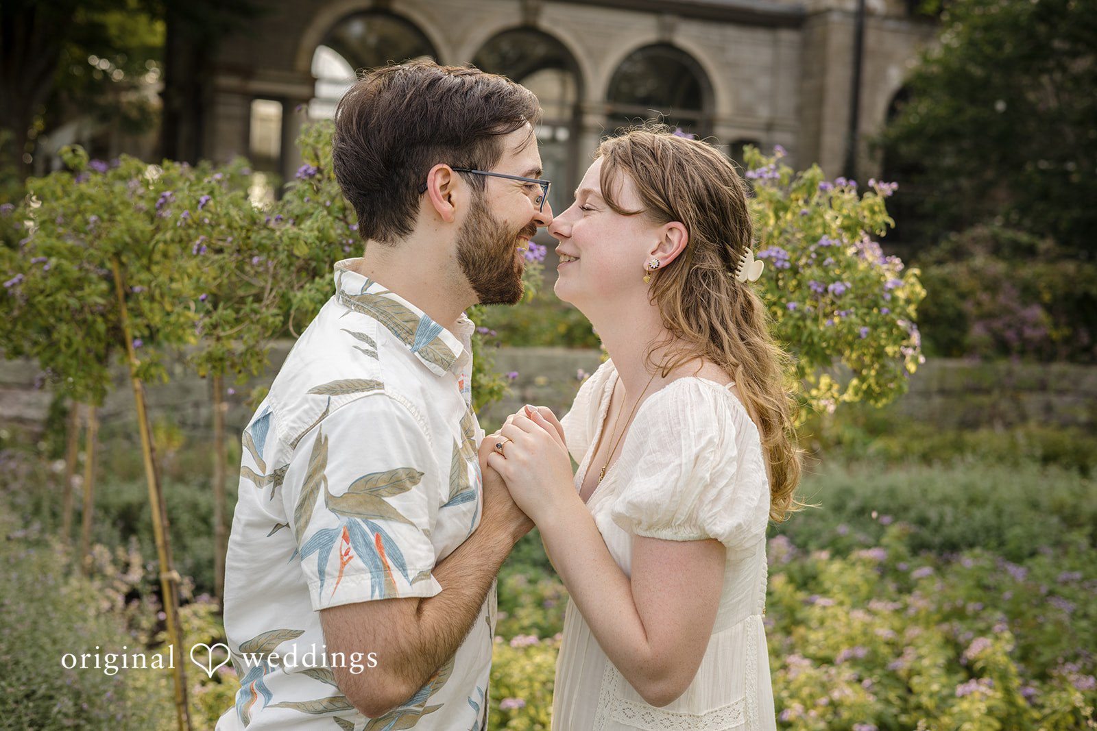 James + Ashlan A man and a woman stand close together smiling face-to-face.