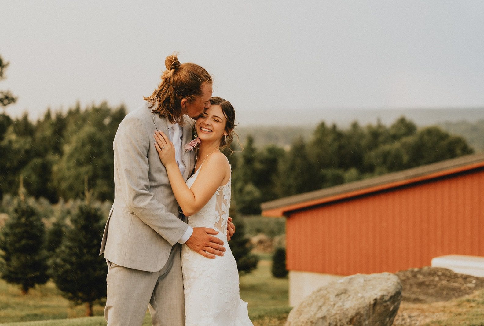 Bride and groom smiling in front of the red barn, captured by Hartford wedding photographers from Original Weddings at Allen Hill Farm