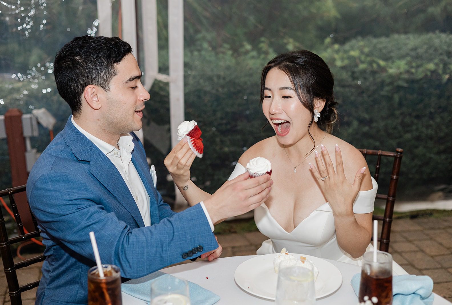 Athena and James laughing together at their sweetheart table, captured by Providence wedding photographers from Original Weddings at Highfield Hall and Gardens
