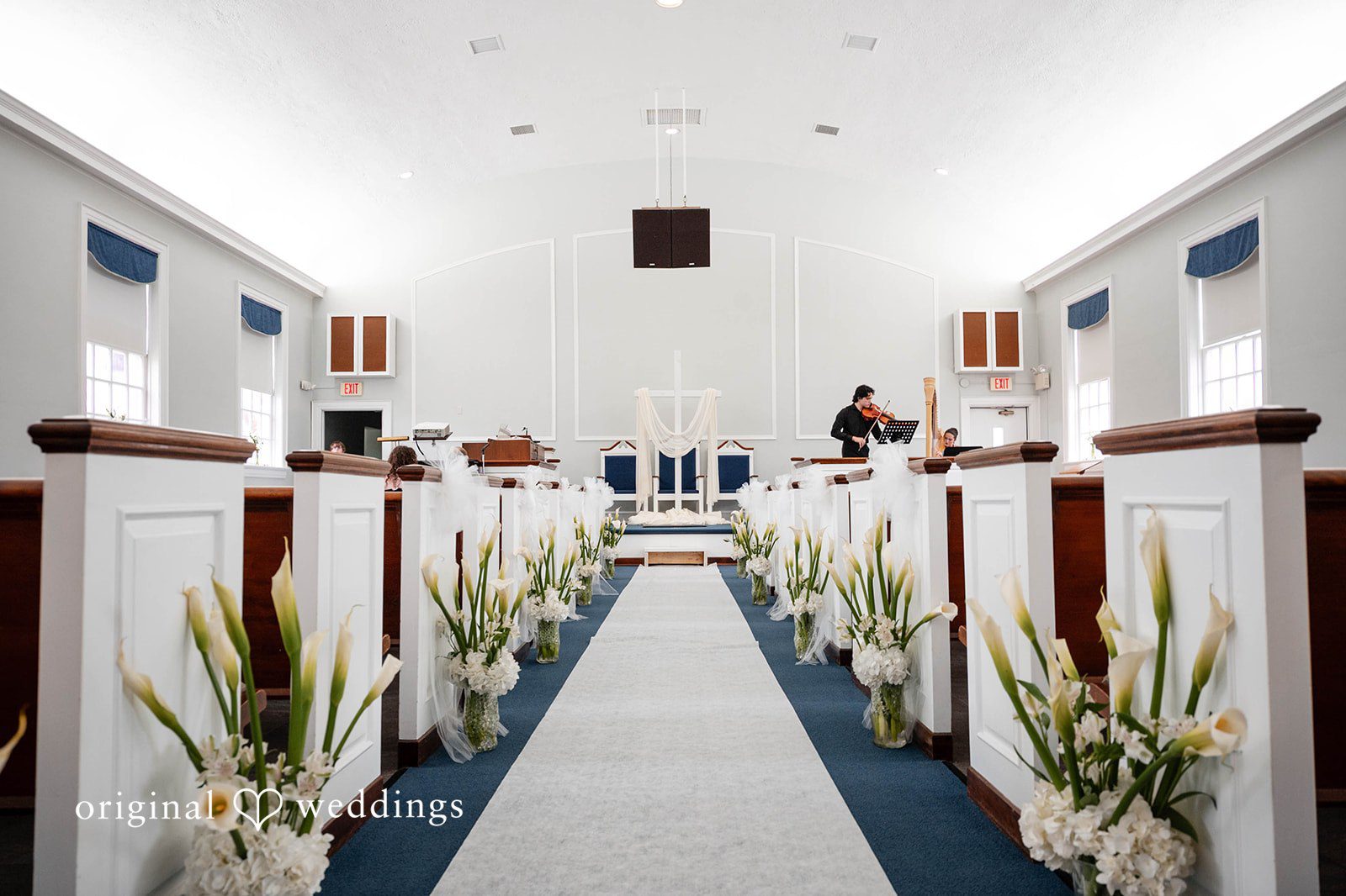 Bethany + Eddie Church sanctuary decorated with white florals at Immanuel Orthodox Presbyterian Church