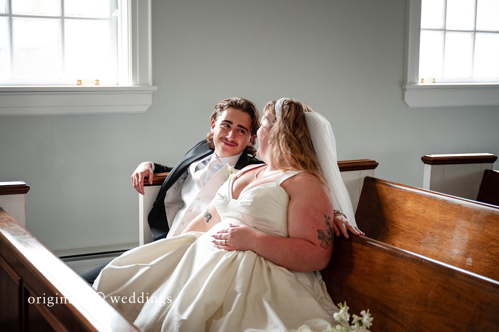 Bethany + Eddie Couple sitting in a church pew at Immanuel Orthodox Presbyterian Church