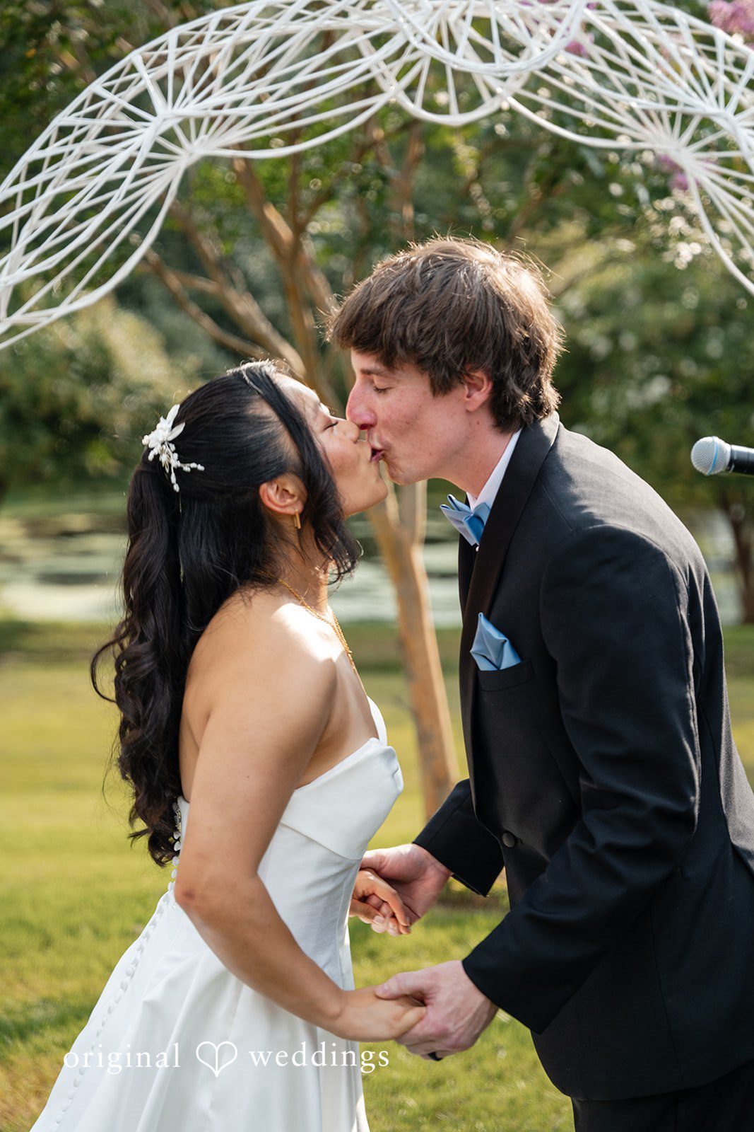 Mae + Corey A bride and groom sharing kiss after wedding ceremony.