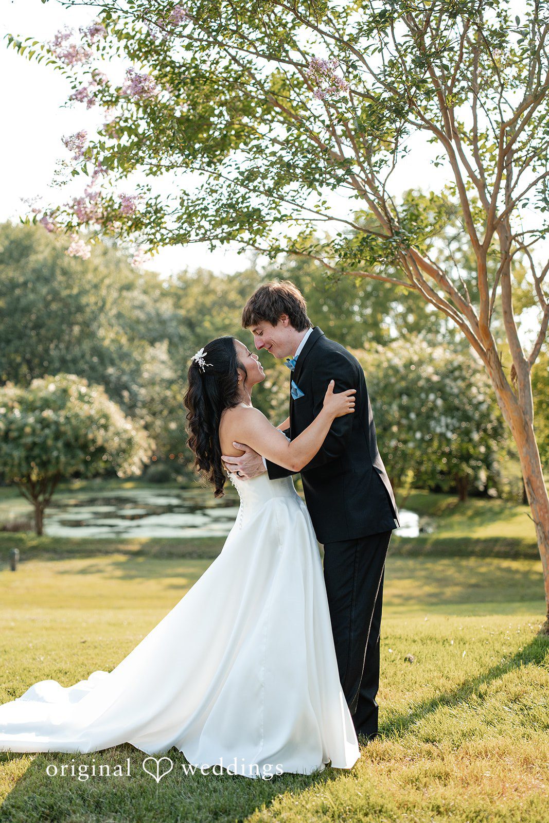Mae + Corey A bride and groom standing together on a lush green lawn.