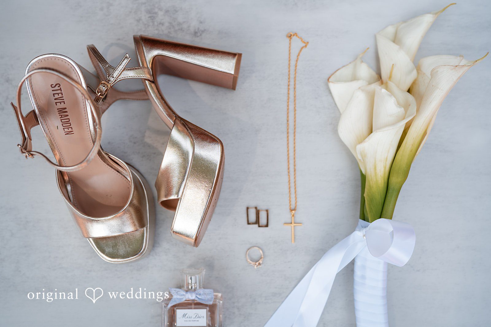Mae + Corey A collection of bridal details including gold heels, jewelry, and a calla lily bouquet.