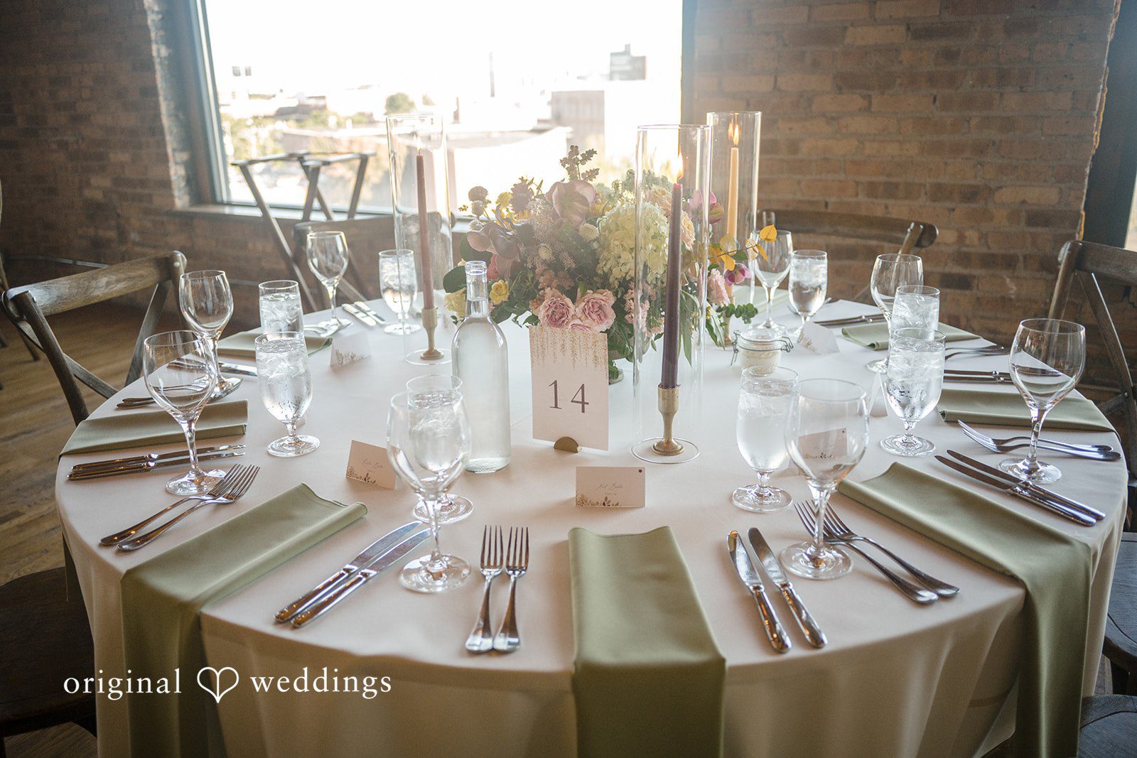 Michael + Haley Round reception table set with candles at Lacuna Lofts