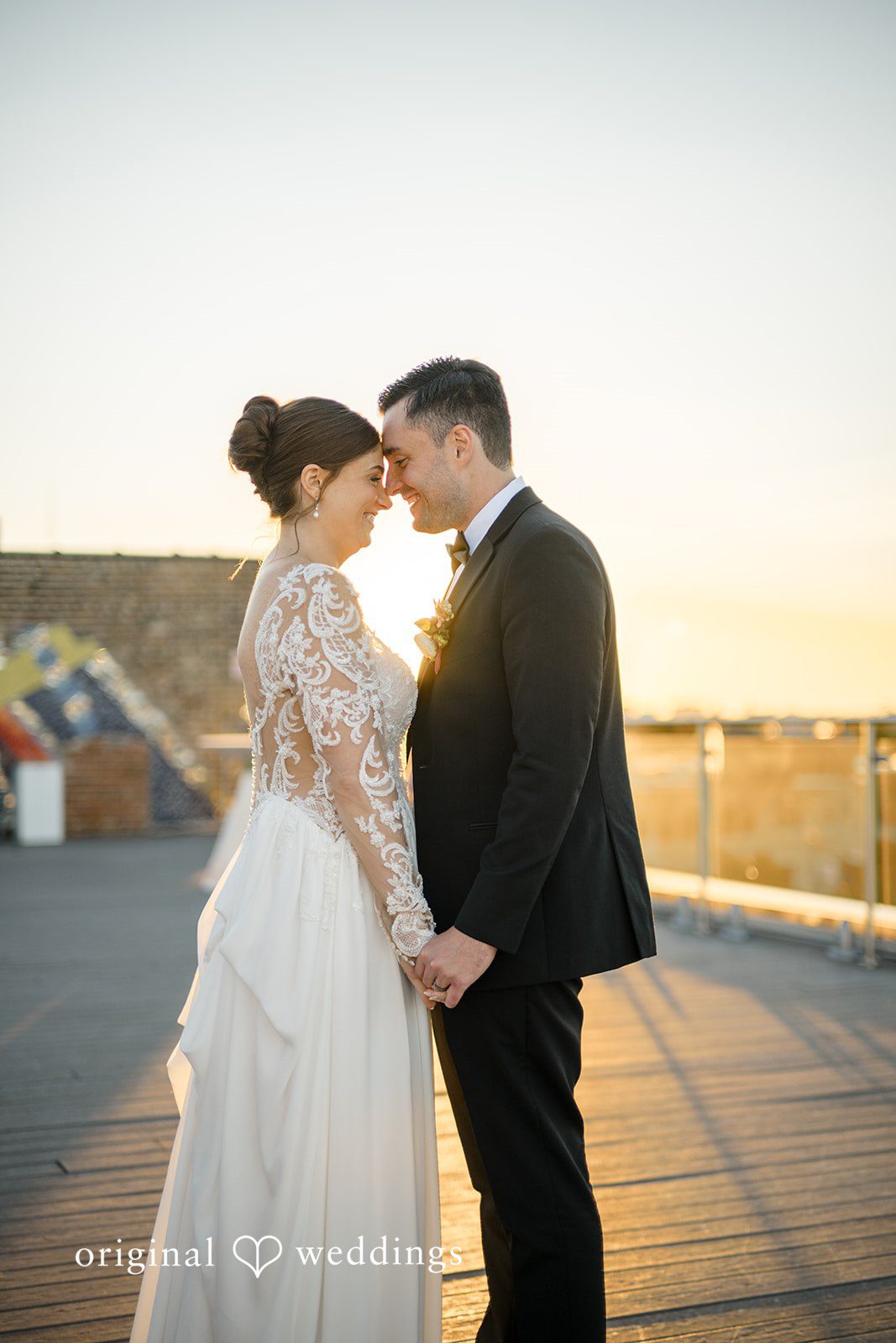 Michael + Haley Couple sharing a kiss at sunset on the rooftop at Lacuna Lofts