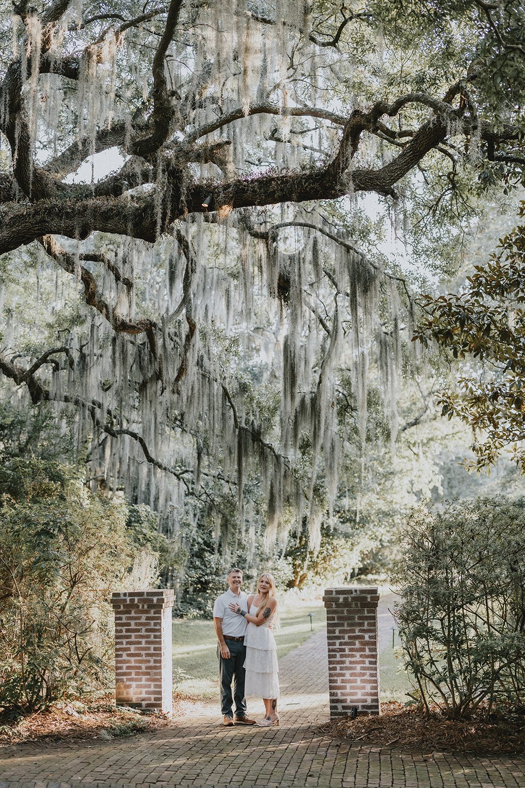 legare-waring-house-rustic-charleston-kaylee-nick-p002-02 Couple walking under the moss draped oaks at Legare Waring House
