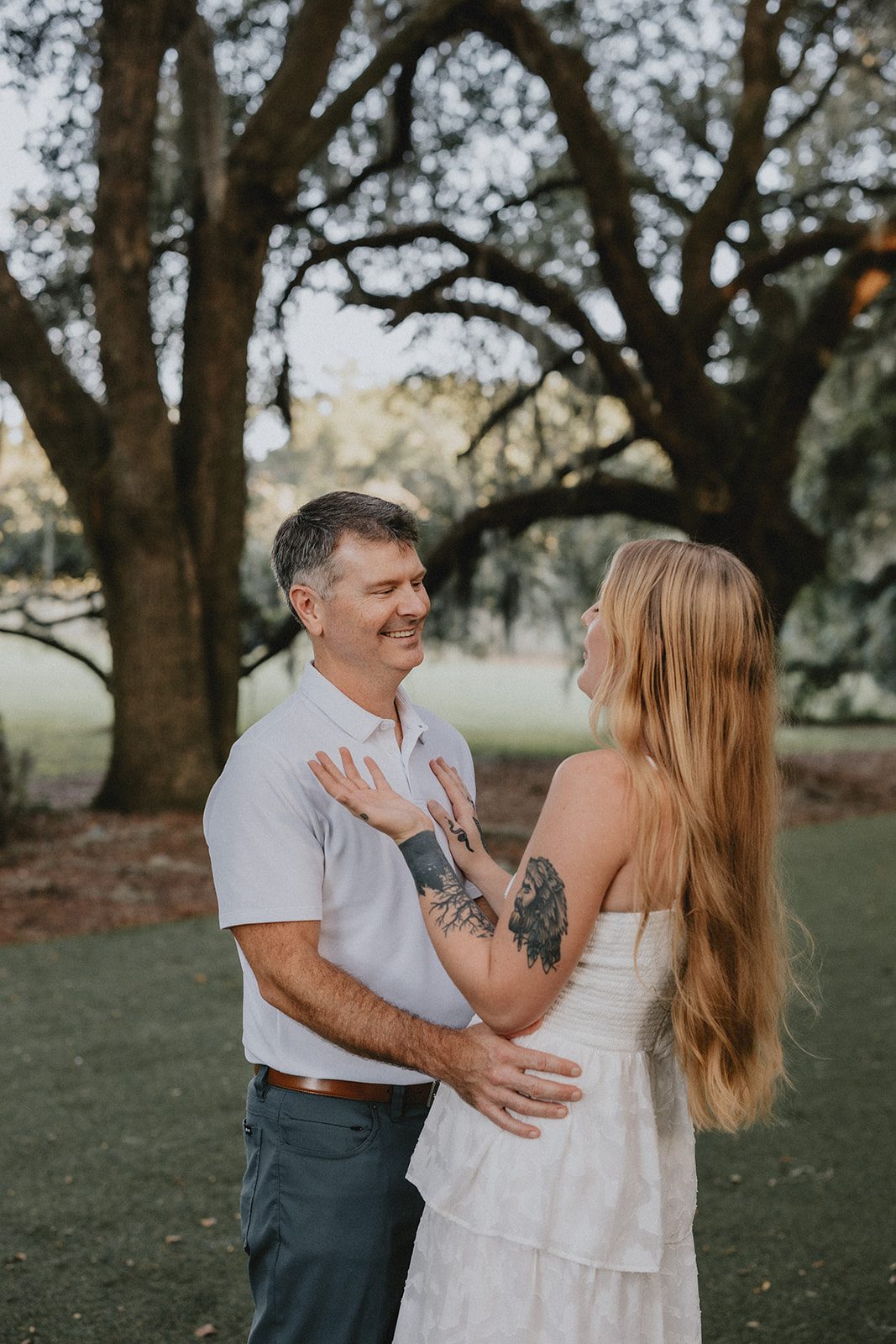 legare-waring-house-rustic-charleston-kaylee-nick-p005-01 Couple embracing under the live oaks, captured with engagement photography services from Original Weddings at Legare Waring House