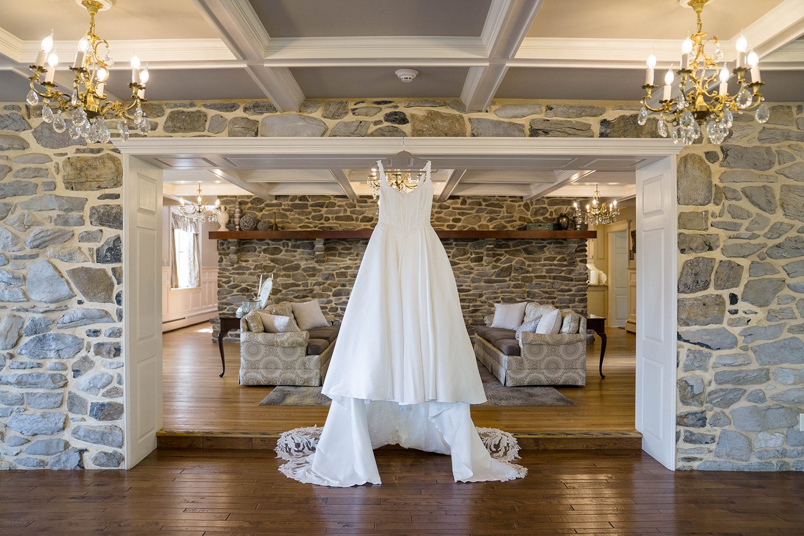 linwood-estate-timeless-baltimore-autumn-dylan-004-46 Wedding dress hanging under a chandelier at Linwood Estate
