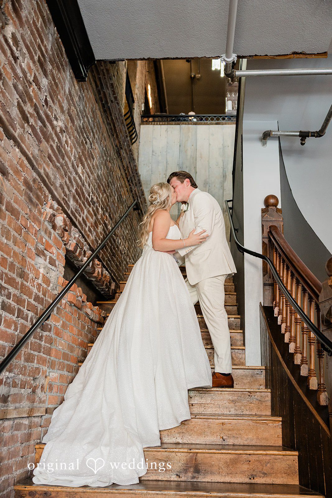 Claire + Alex The couple shares a kiss by the stairs