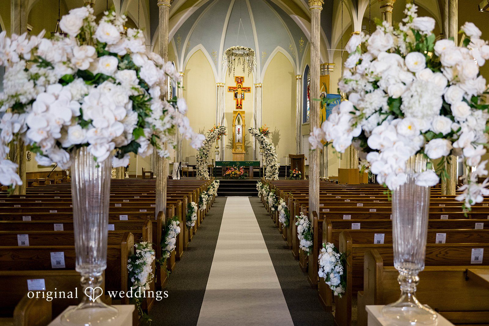 Sierra + Arturo Church aisle lined with white floral arrangements