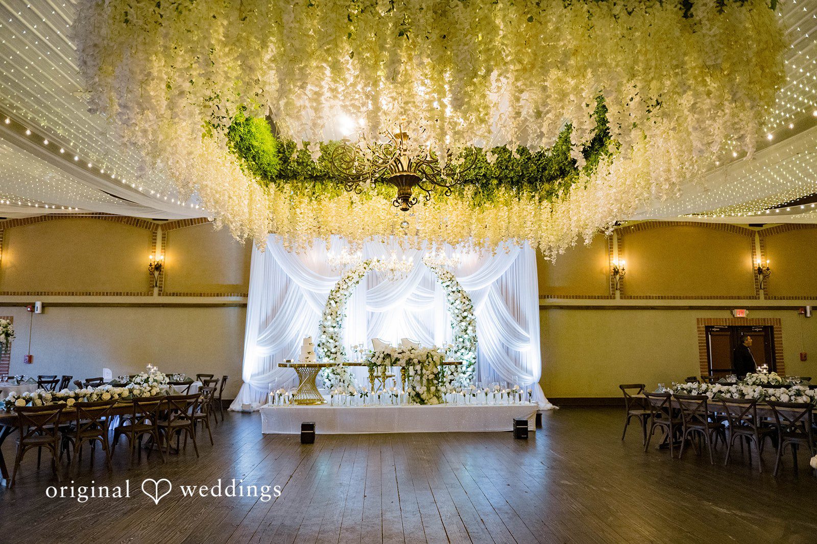 Sierra + Arturo Reception hall with hanging greenery and white drapes at Rancho Los Guzman
