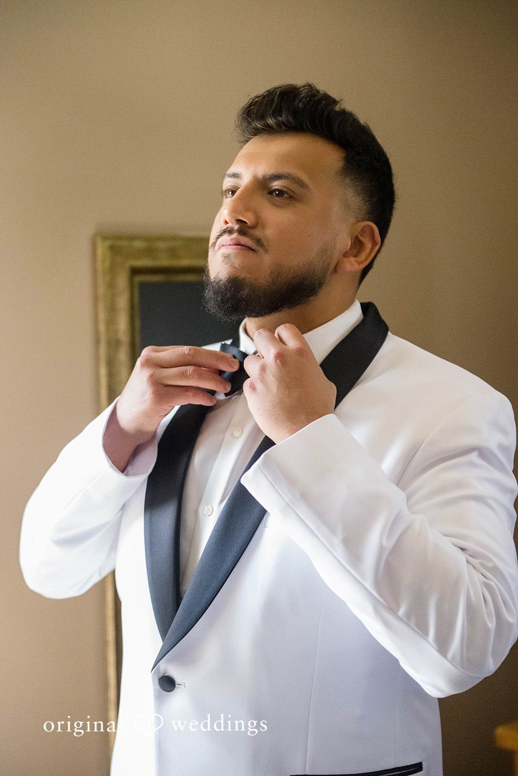 September 12, 2026 – Sierra & Arturo – (ID-4123) Groom fixing his bow tie in a white tuxedo jacket