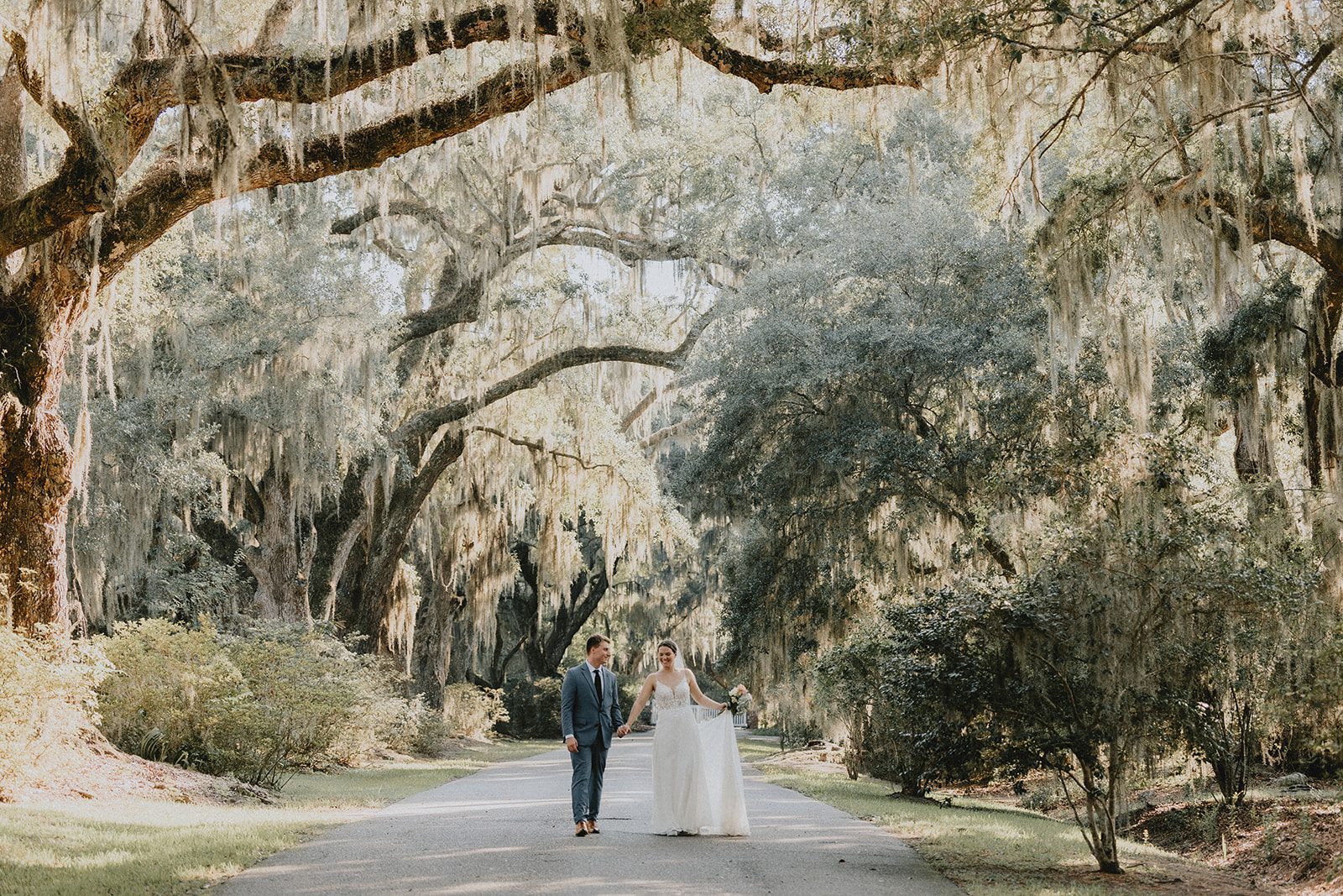 Couple walking under the oak trees at Magnolia Plantation and Gardens Couple walking under the oak trees at Magnolia Plantation and Gardens