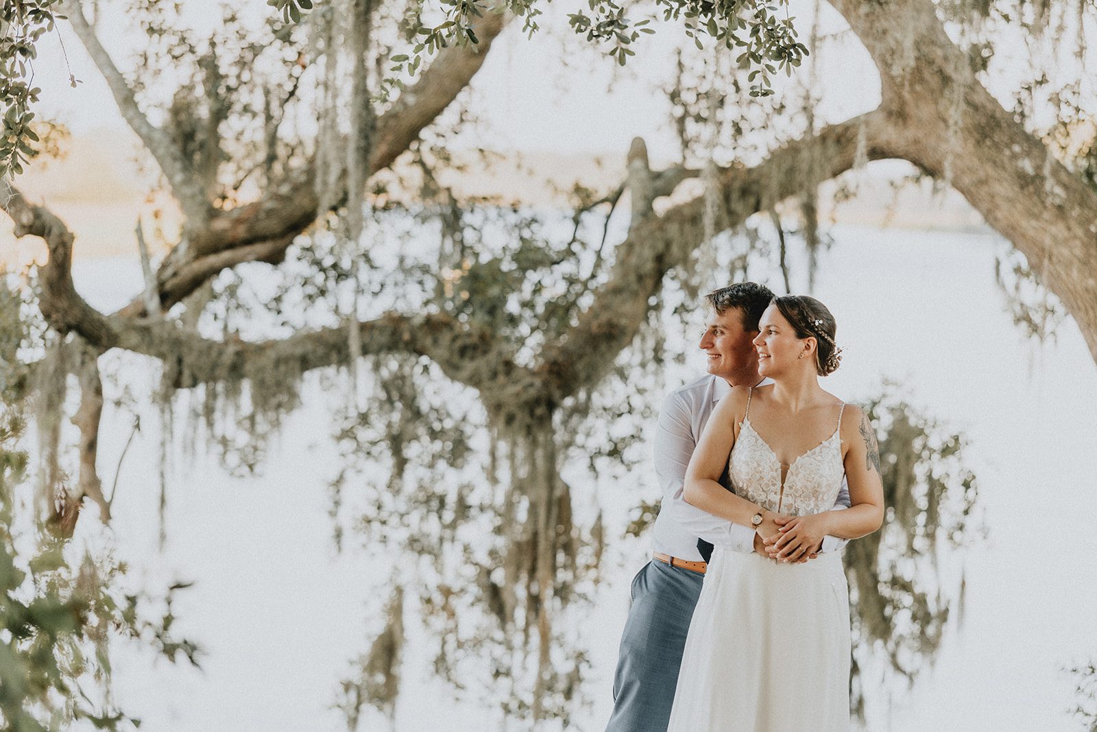 Couple standing close under the moss, captured by Charleston wedding photographers Couple standing close under the moss, captured by Charleston wedding photographers