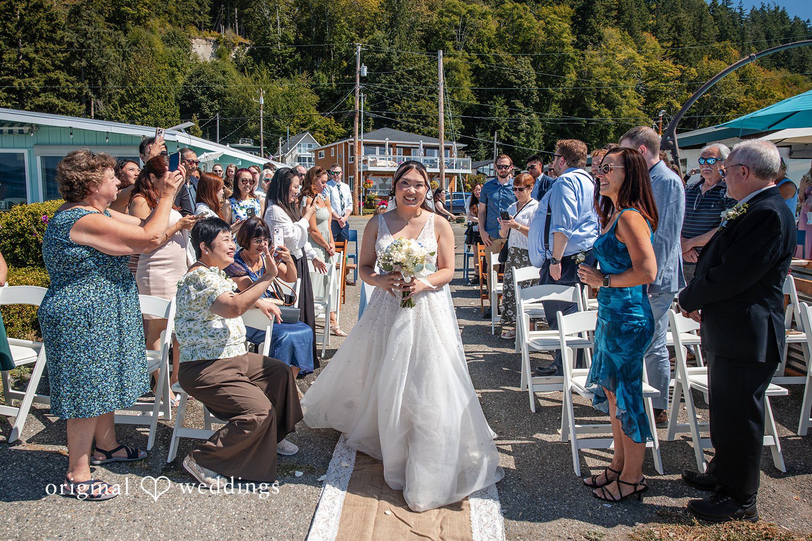 Kelly + John Bride walking down the aisle as guests watch