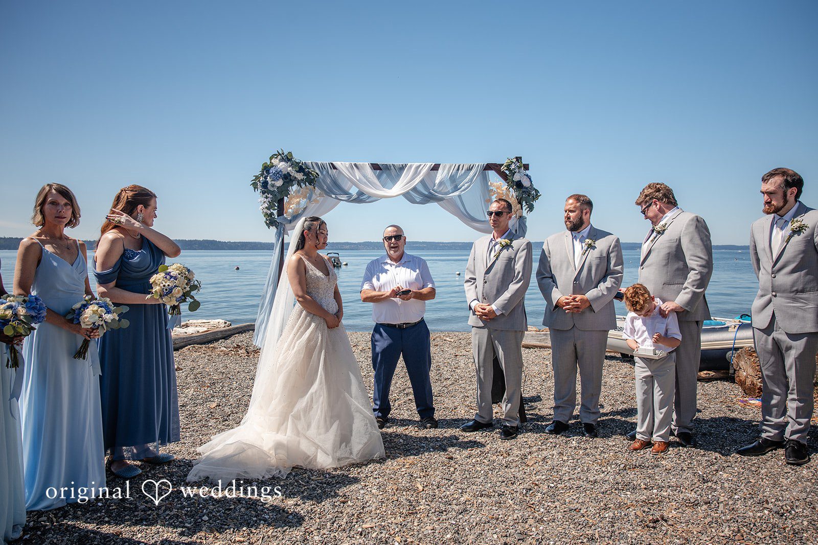 Kelly + John Wedding party standing at the ceremony arch