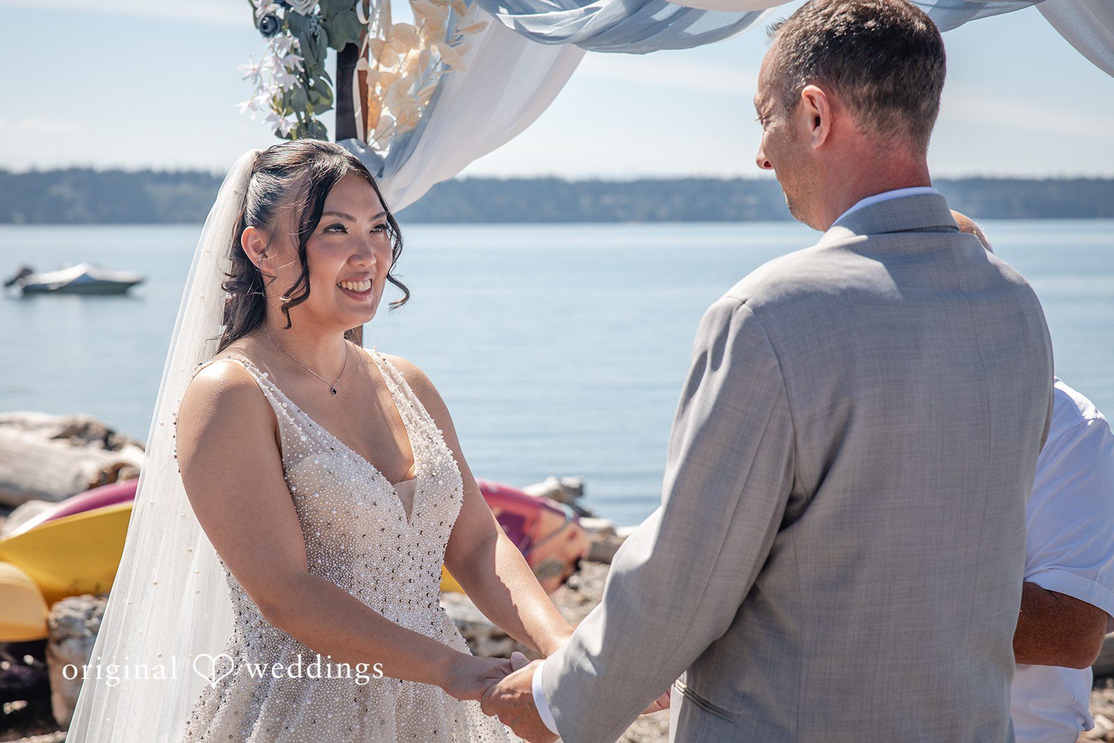 Kelly + John Couple holding hands during the vows at Mckees Beach