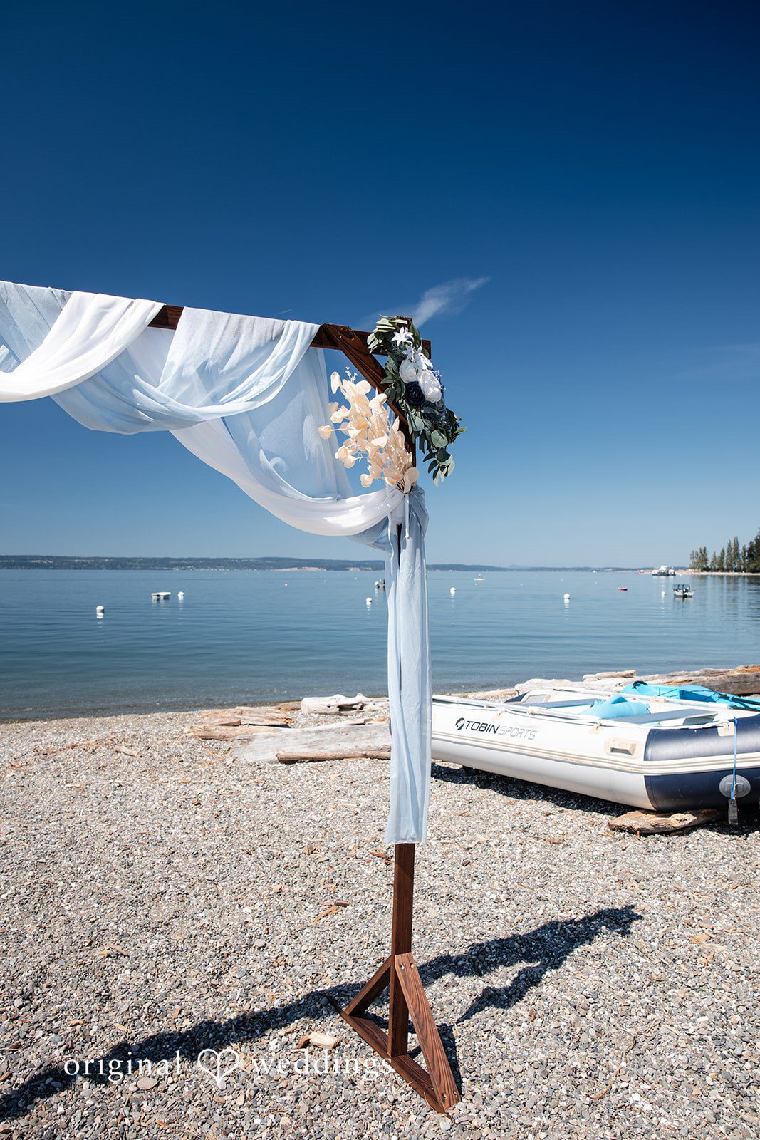 Kelly + John Ceremony arch with flowing fabric on the beach at Mckees Beach