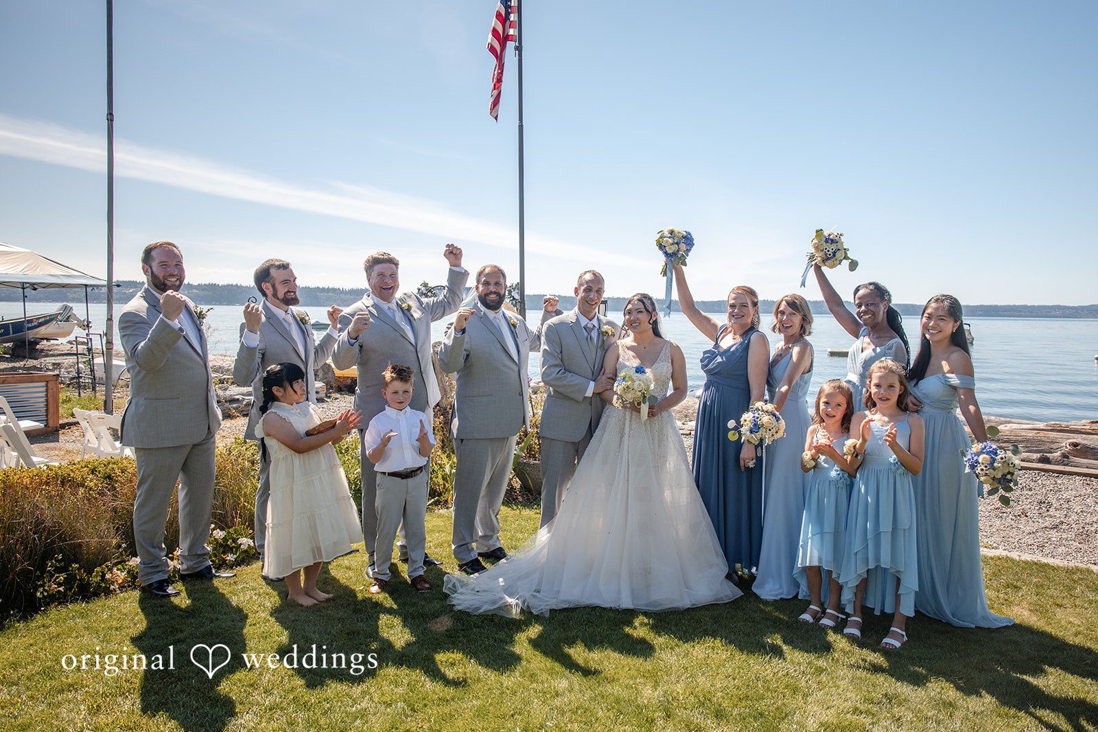 Kelly + John Wedding party cheering by the water at Mckees Beach