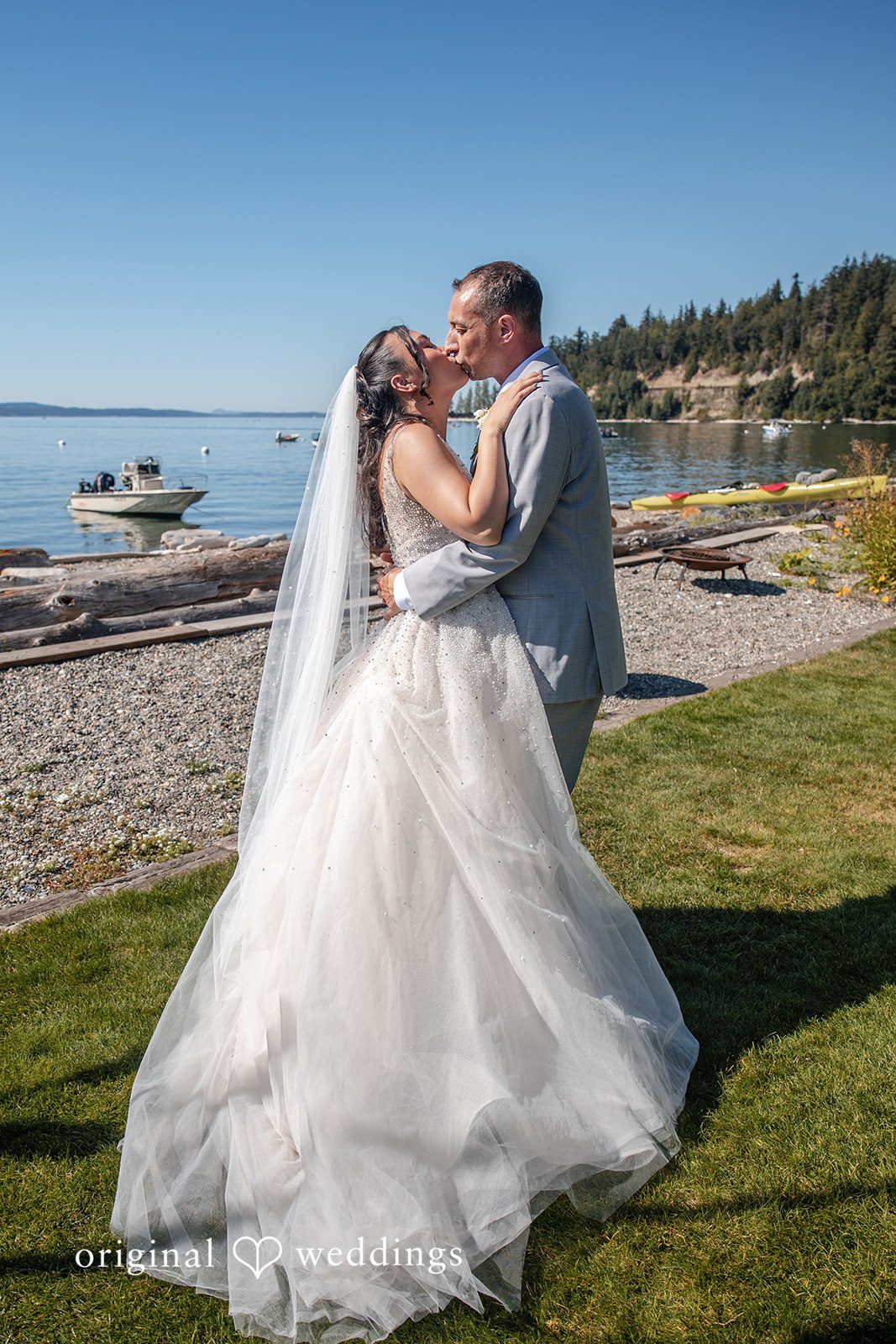 Kelly + John Couple kissing by the water at Mckees Beach