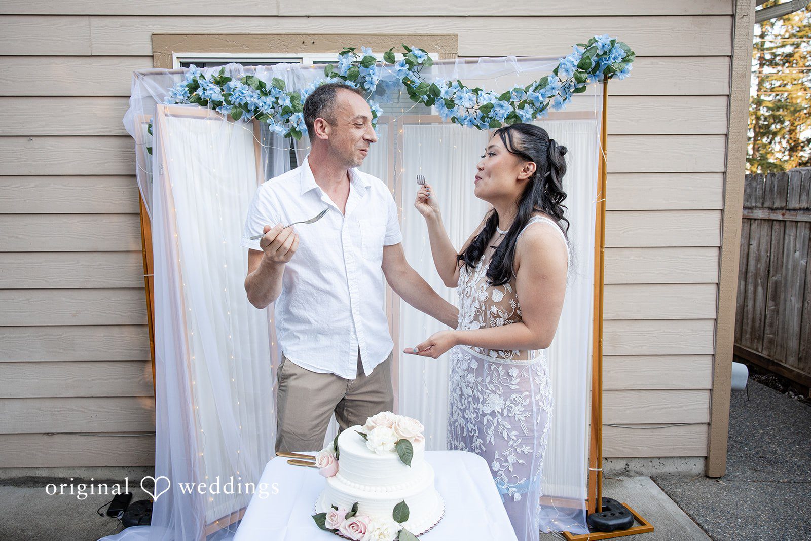 Kelly + John Couple cutting their cake in the backyard