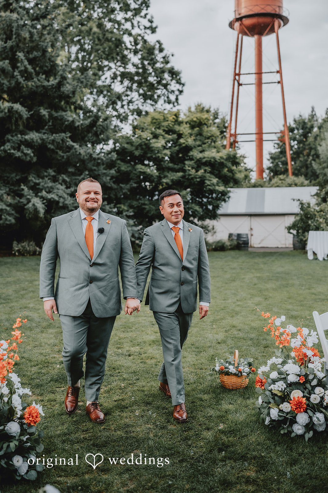 Benjamin + Tuan Couple walking with the water tower behind them at McMenamins Edgefield
