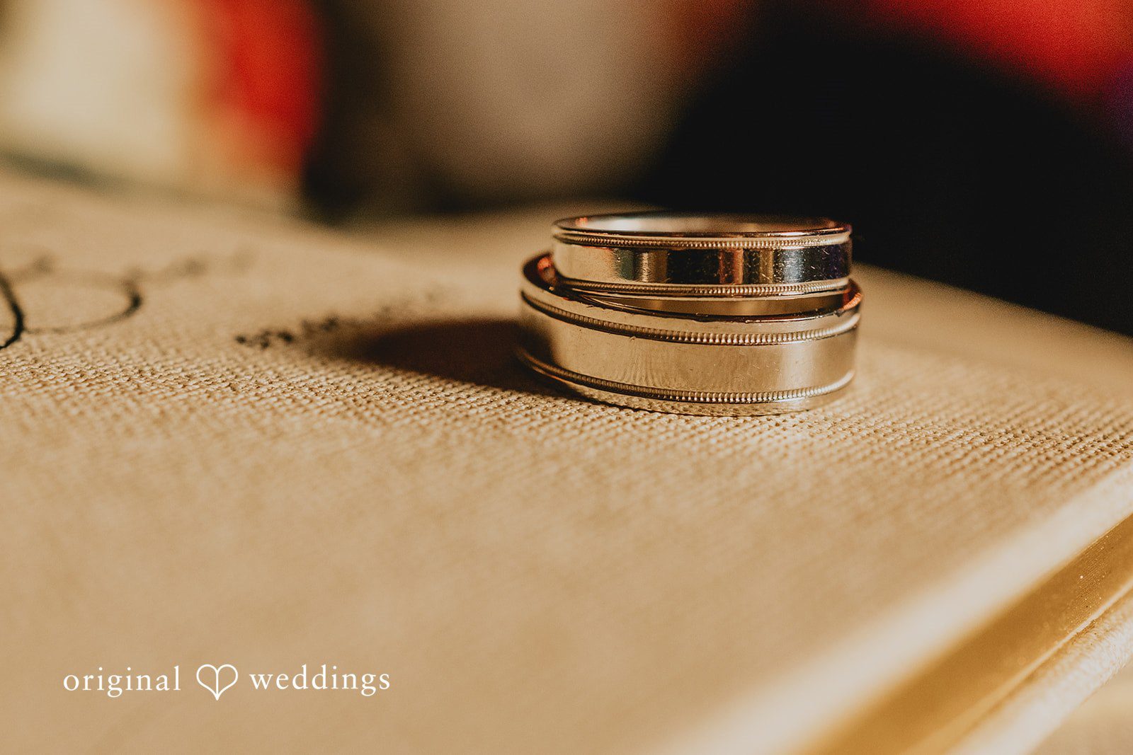 Benjamin + Tuan Wedding rings resting together in warm light