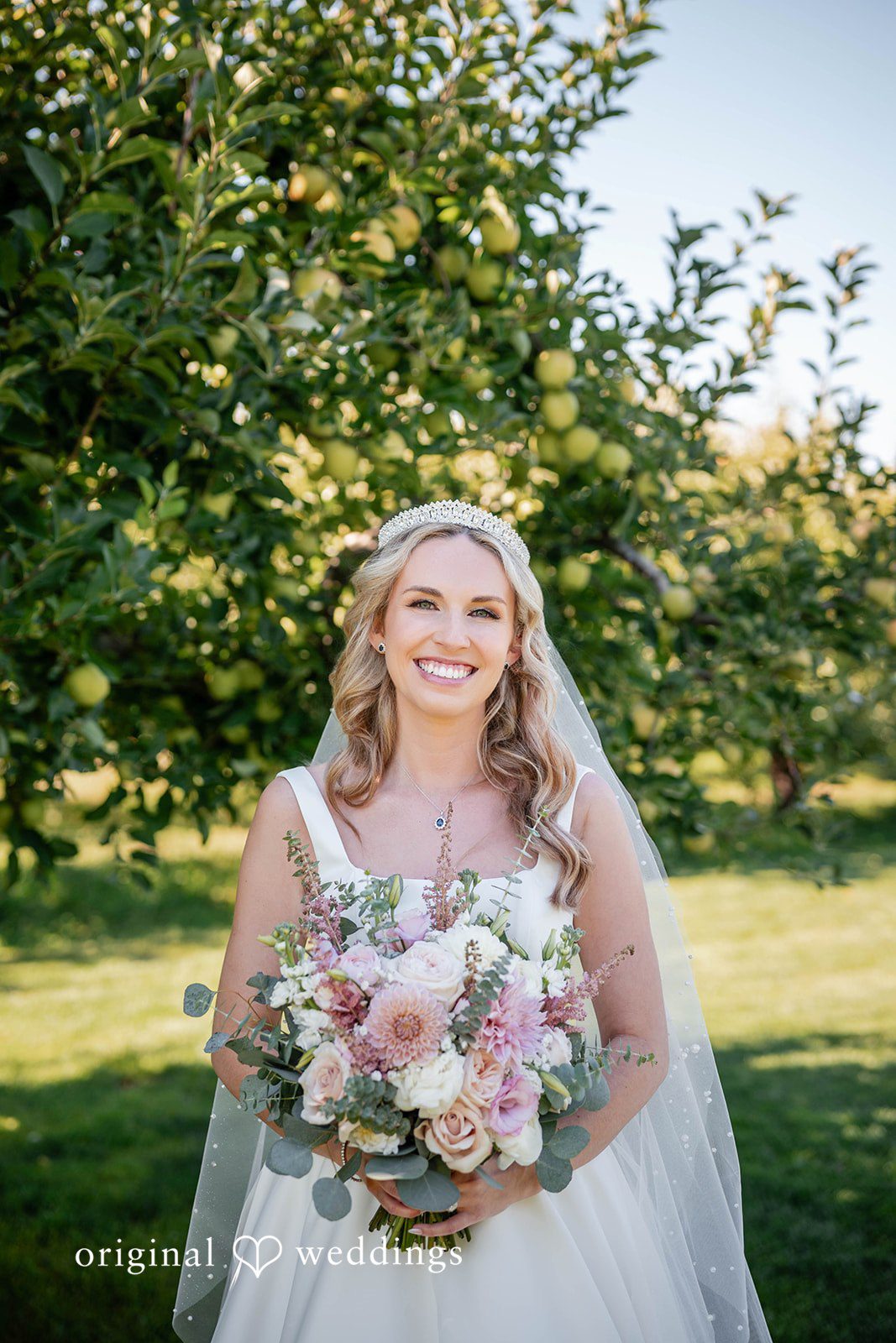 Bride holding her bouquet in the orchard