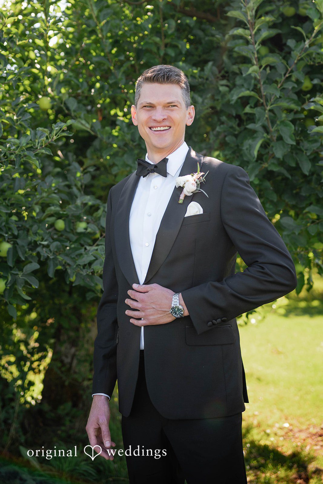 Groom portrait among green trees