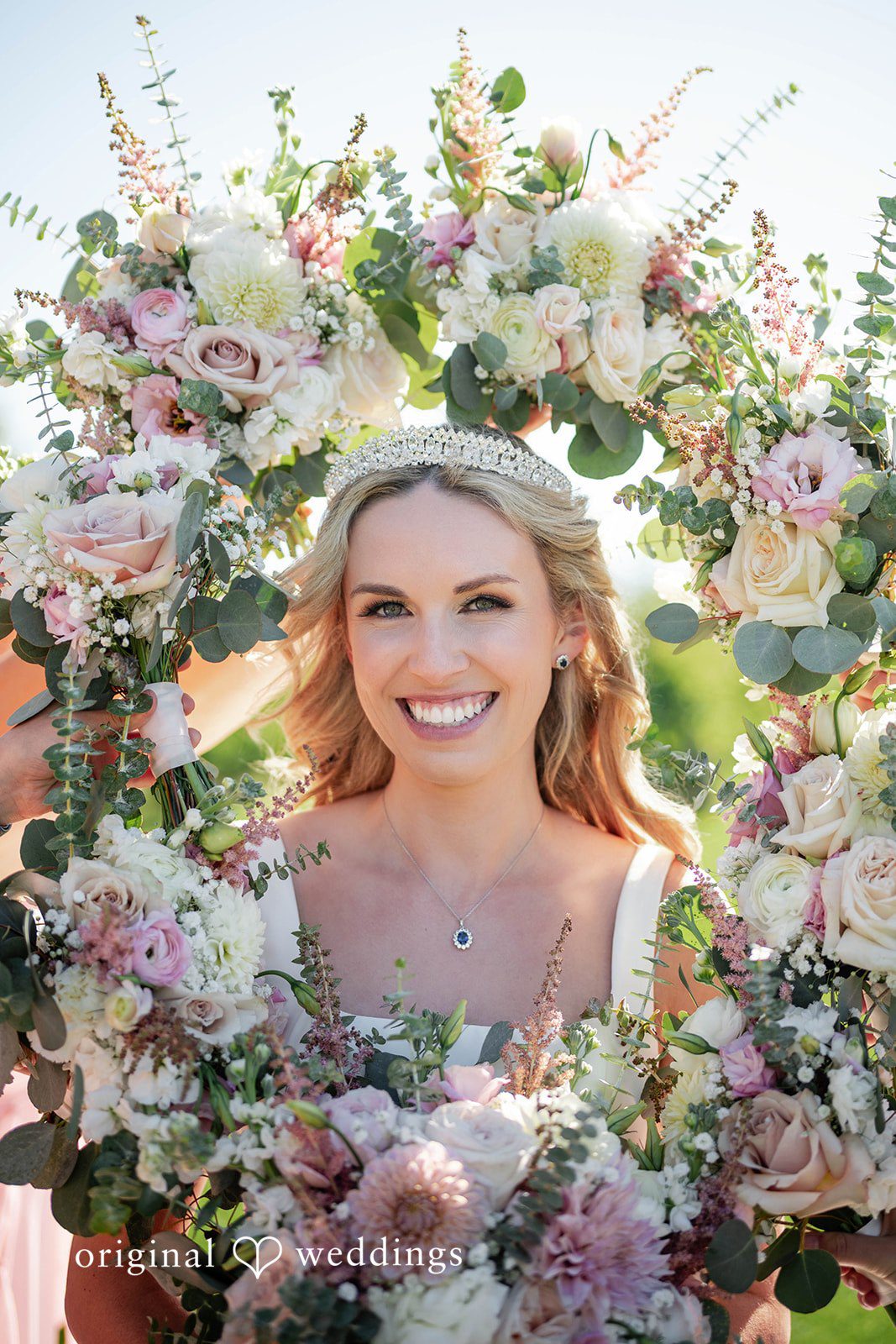 Bride smiling with a full floral bouquet