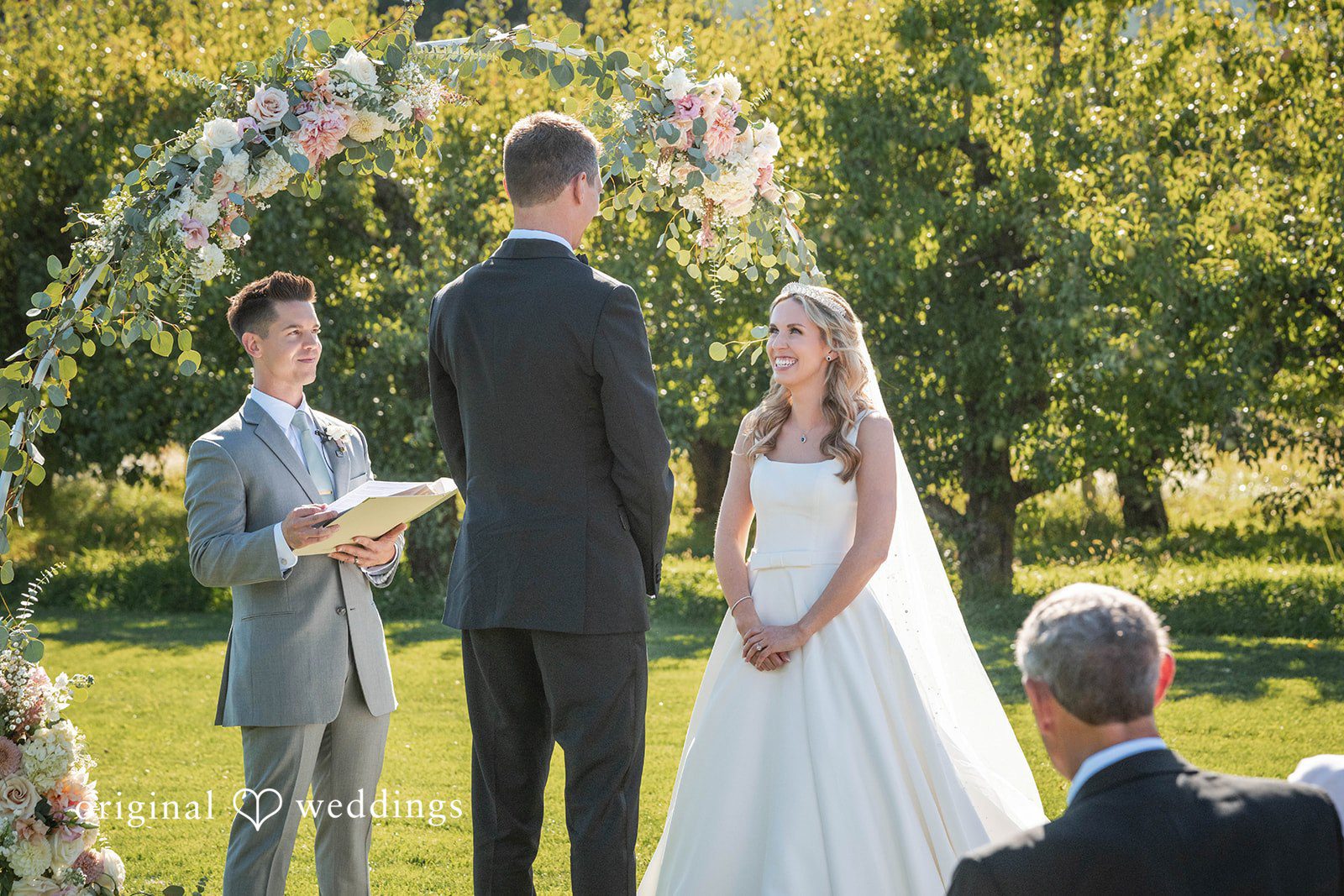 Couple standing with the officiant during the ceremony at Mt View Orchards