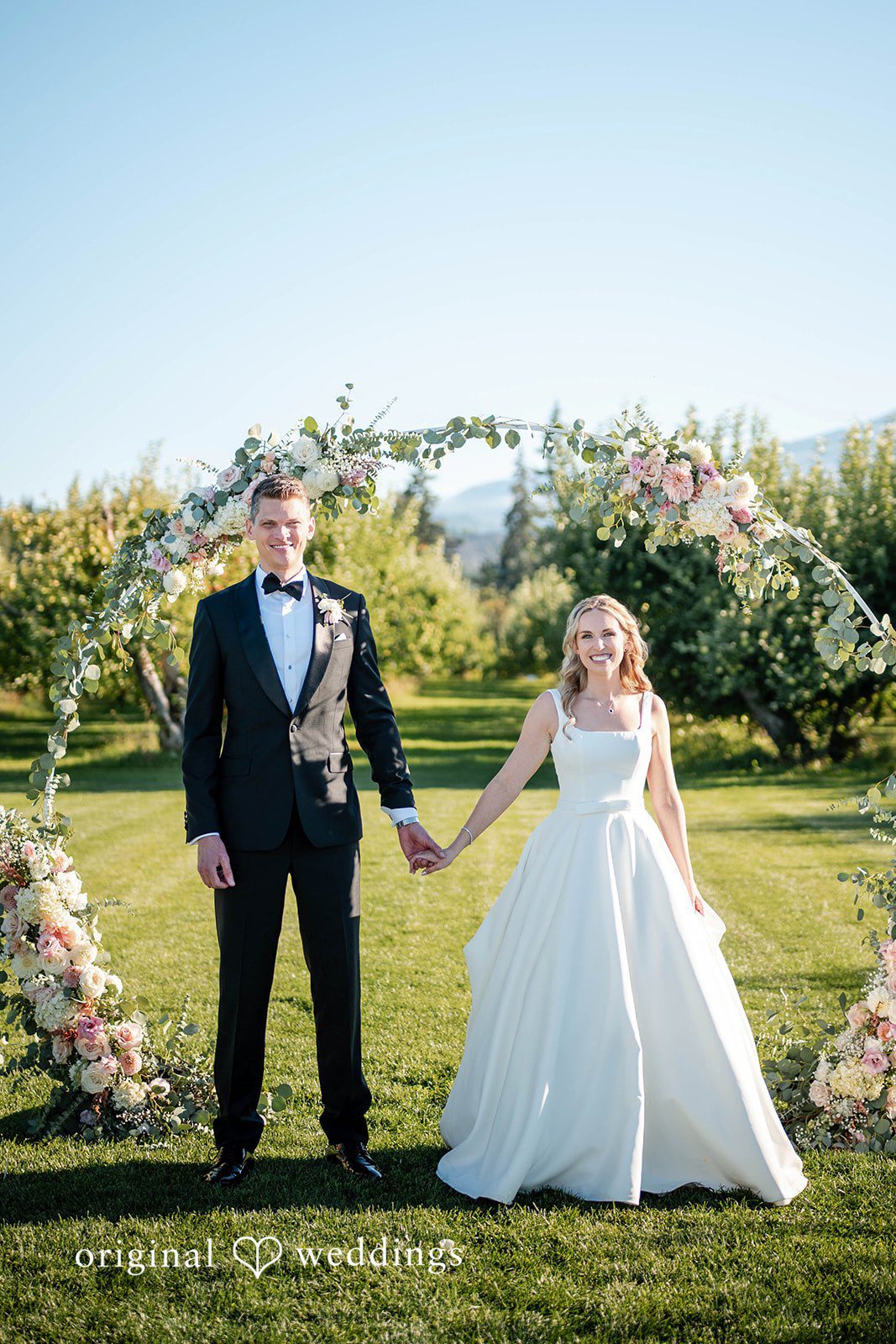 Couple facing each other under the floral arch