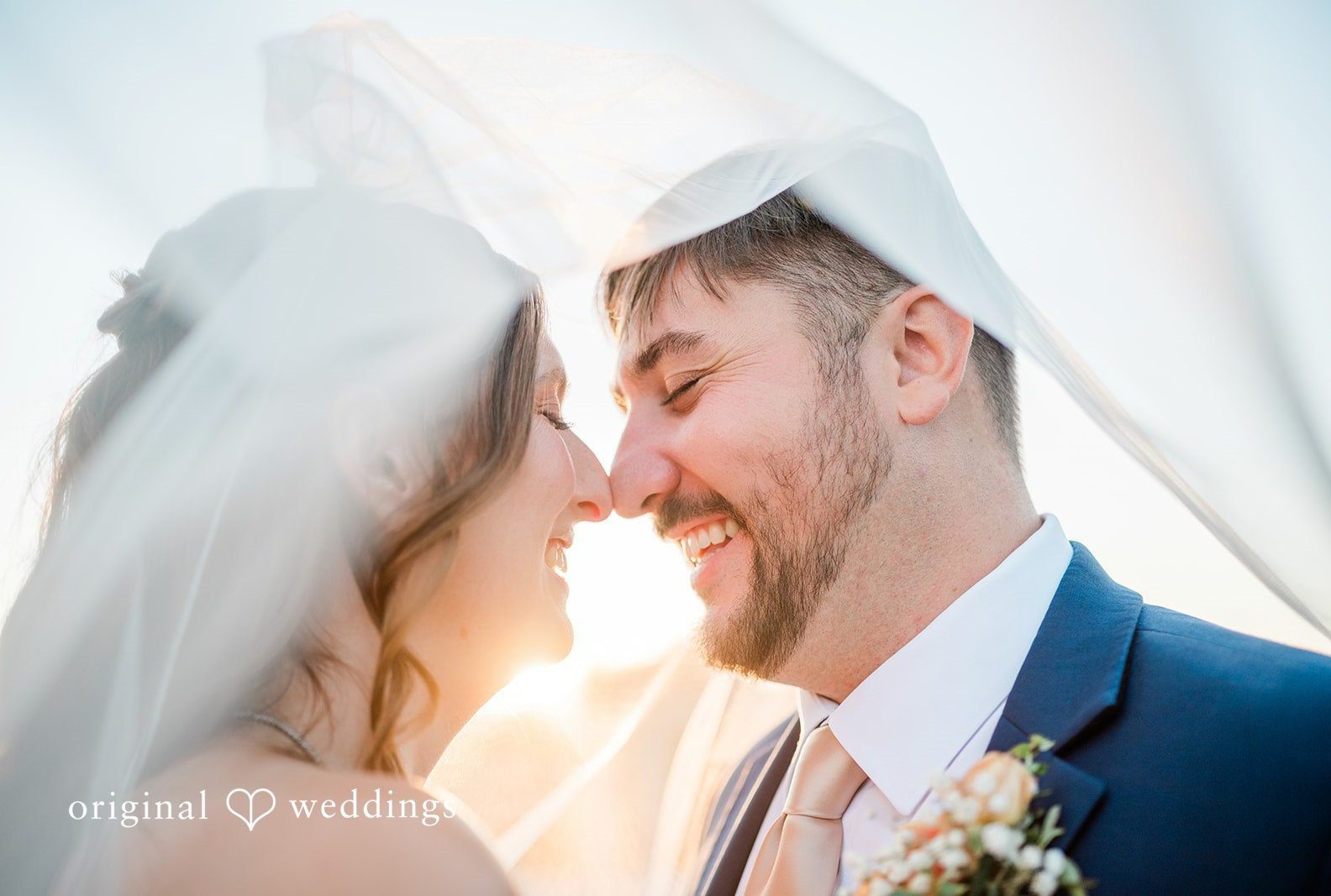 Bride and groom smiling under her veil, captured by Cincinnati wedding photographers from Original Weddings at Muhlhauser Barn